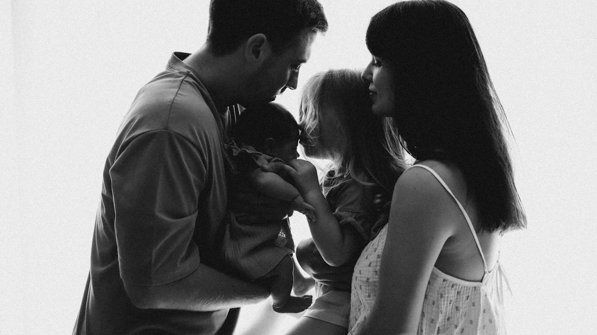A black and white photo of a family looking at each other